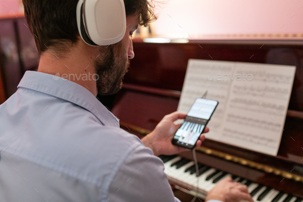 Man teaching piano lessons with remote smartphone connection