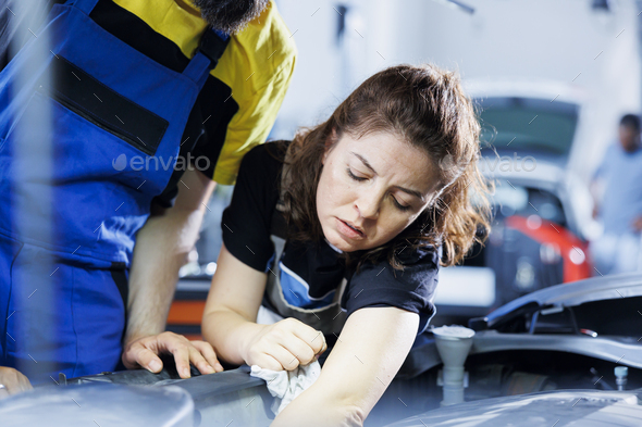 Technicians in garage fix car fuel tank