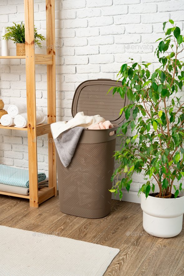 Pile of clothes in plastic laundry basket in the bathroom Stock Photo