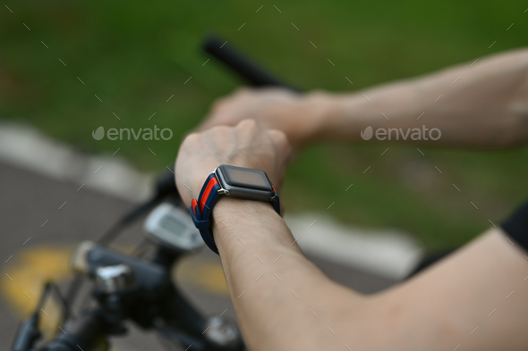 Cropped image of man cyclist checking sport activity progress data on smartwatch.