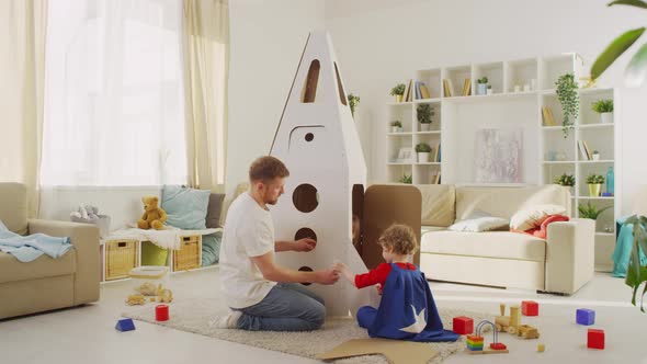 Father and Son Construct Toy Rocket alt