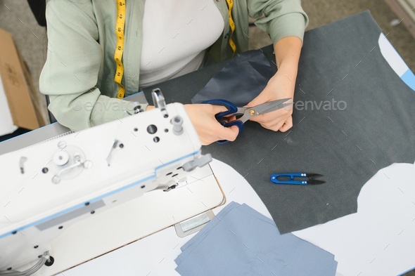 Portrait of a beautiful seamstress carrying a tape measure and