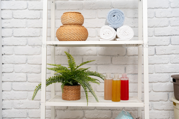 Rolled fluffy towels on shelf in bathroom Stock Photo by FabrikaPhoto