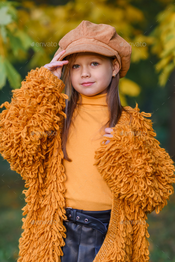 beautiful little girl in a red sweater and a red cap with an umbrella ...