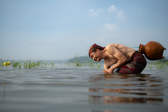 Fisherman using traditional fishing gear to catch fish for cooking, Stock  Photo by wosunan