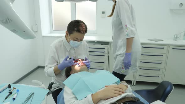 Dentist treating a patient alt