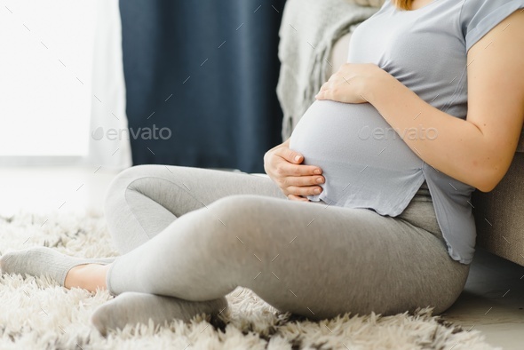 Premium Photo  Pregnant woman caressing her belly at home. young expectant  blonde feeling her baby push, sitting on floor, copy space. pregnancy,  rest, life, expectation concept