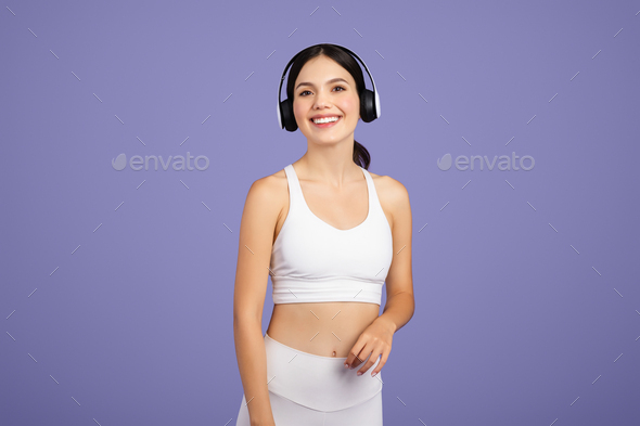 Fit European woman in sportswear, headphones on, resting post-workout