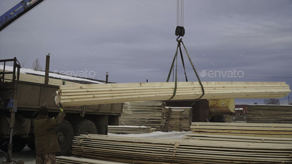 Wooden planks are lifted by crane for transportation. Clip. Loading of wooden boards for