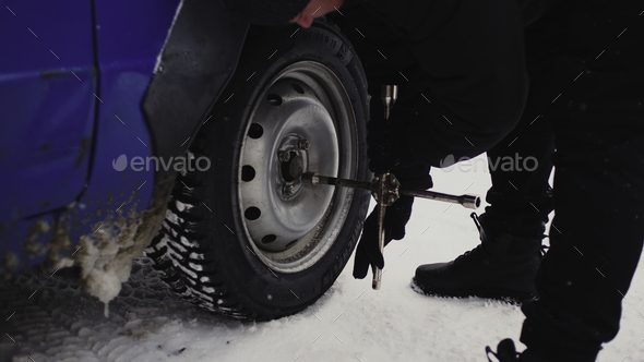 Close-up of spinning wheels in winter. Clip. Man spins wheels on highway in winter. Man changed the