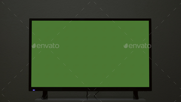 Plasma TV with green screen stands on background wall. Concept. Green-screen TV stands on background