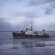 Premium Photo  Fishing boat floats on background of cloudy winter  landscape clip fishing boat with flag sails by