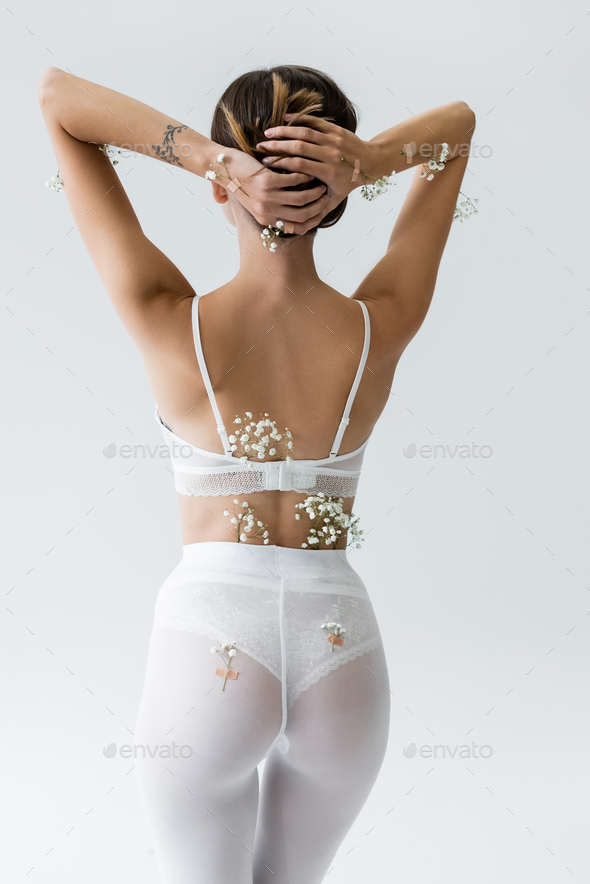 back view of slim woman in white bra and tights, with tiny flowers