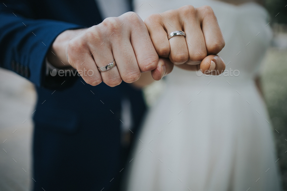 Married couple crossed hands with gold wedding rings Stock Photo by fotojv