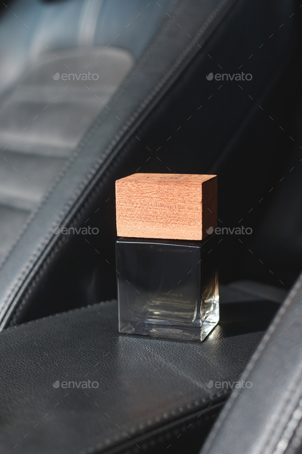 Car Perfume in glass jar with wooden lid for Vehicle fragrance. Bottle inside the car on car panel.