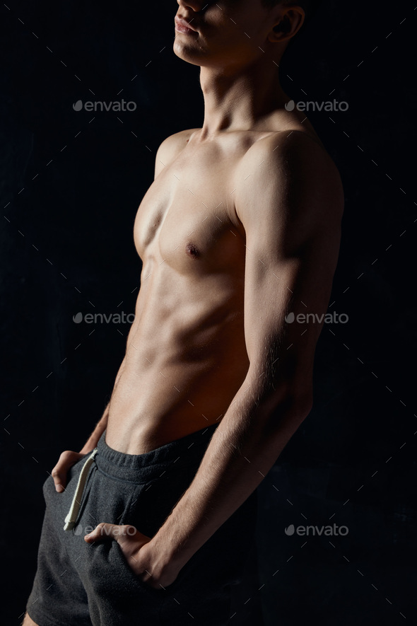 Bodybuilder With A Naked Torso On A Black Background Side View Fitness