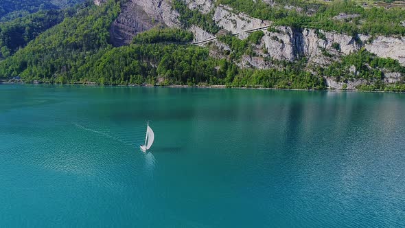 Aerial video of a sail boat cruising along Walensee Lake in Switzerland during Summer (1) alt