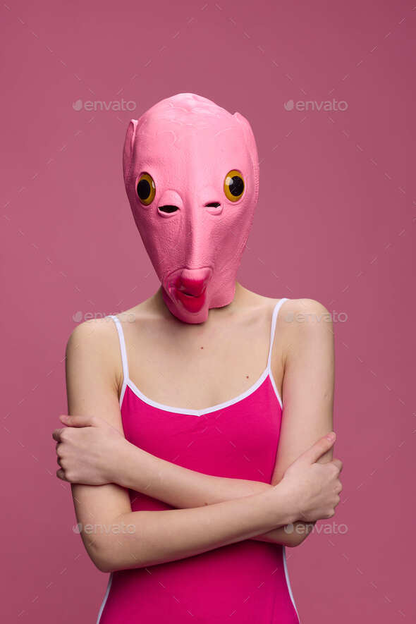 Conceptual art photo of a sexy woman in a fish mask for Halloween on a pink  background Stock Photo by shotprime