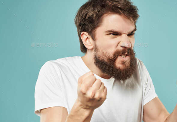emotional man with a beard in a white t-shirt emotions anger