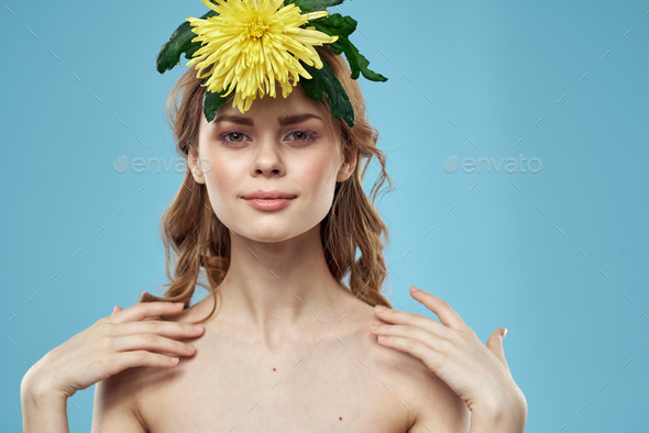 Women With Yellow Flower On Head On Blue Background Naked Shoulders