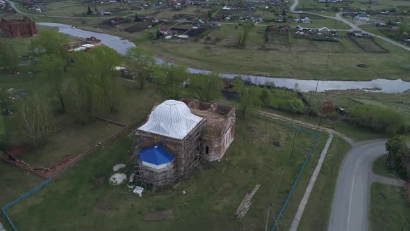 Aerial view of old village with church and old houses on the high bank of the river 07 alt