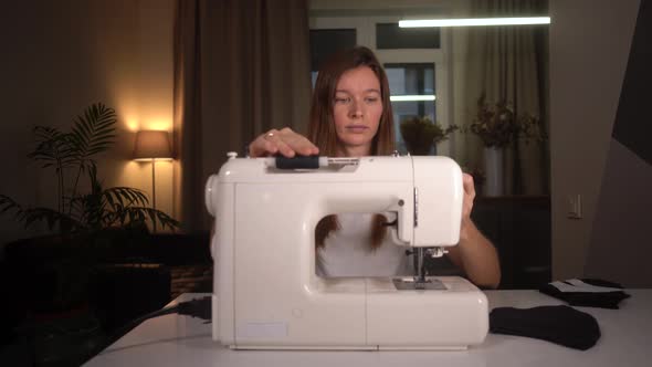 Woman Refills Sewing Machine at Home