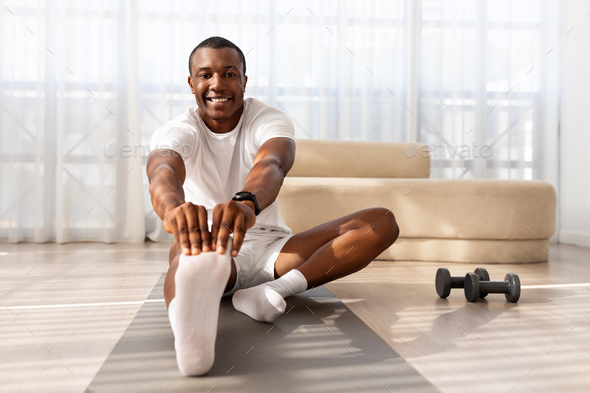 Athletic millennial black man warming up and stretching Stock Photo by  Prostock-studio