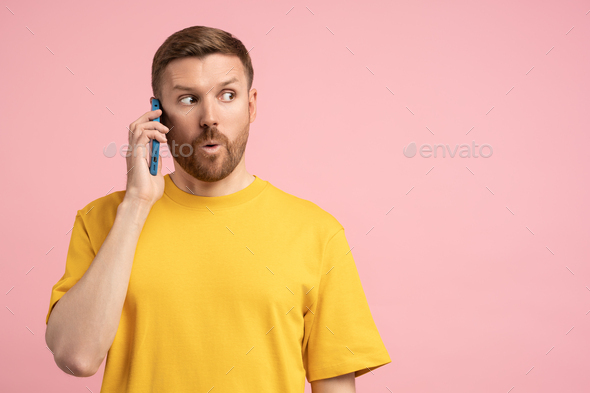 Shocked Man Holding Cellphone Surprised Pointing Wow Eyes At Copy Space