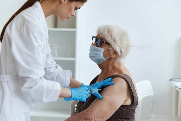 elderly woman wearing a medical mask syringe injection vaccine passport immunity protection