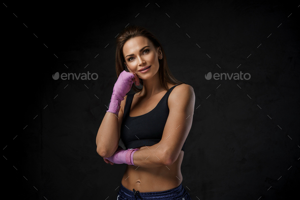 Athletic beauty in black, winding boxing hand wraps
