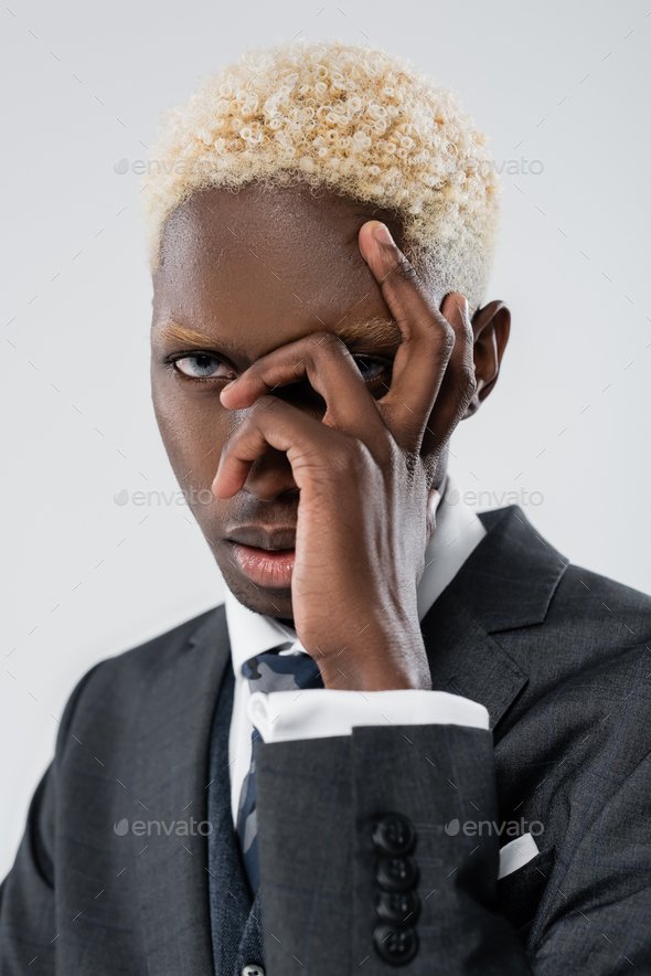 blonde african american man with blue eyes looking at camera