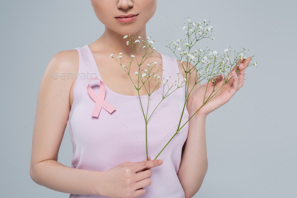 cropped view of woman in tank top posing with pink awareness ribbon and  gypsophila flowers isolated