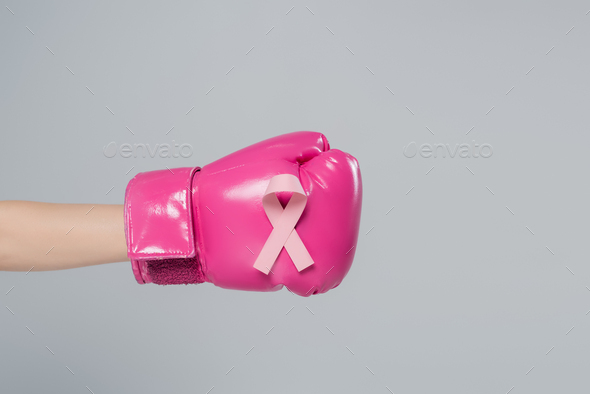 partial view of female hand with breast cancer awareness ribbon on pink boxing glove isolated on