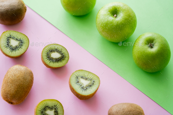 flat lay of organic kiwi fruit on green and pink Stock Photo by  LightFieldStudios