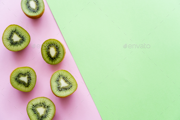 flat lay of organic kiwi fruit on green and pink Stock Photo by  LightFieldStudios
