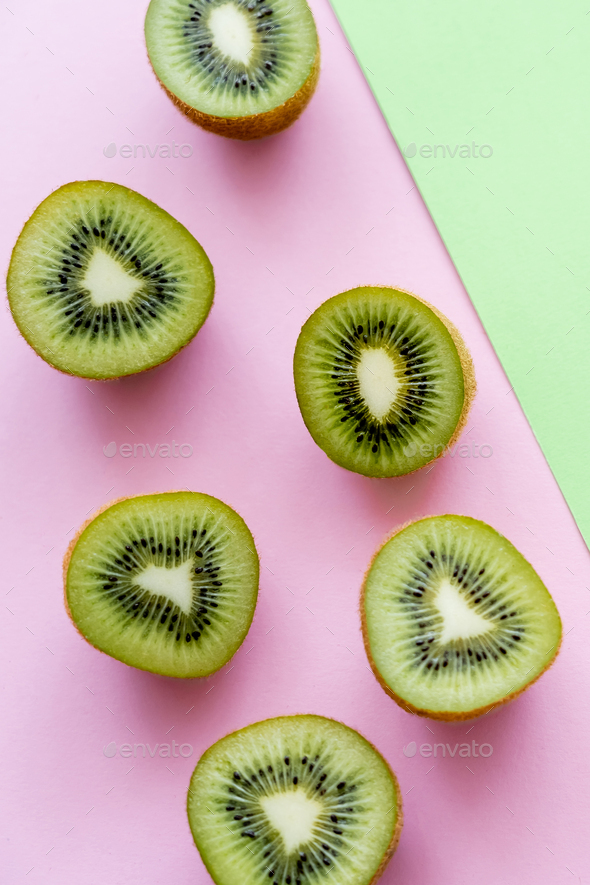 flat lay of organic kiwi fruit on green and pink Stock Photo by  LightFieldStudios