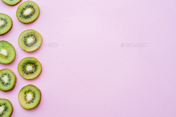 flat lay of organic kiwi fruit on green and pink Stock Photo by  LightFieldStudios