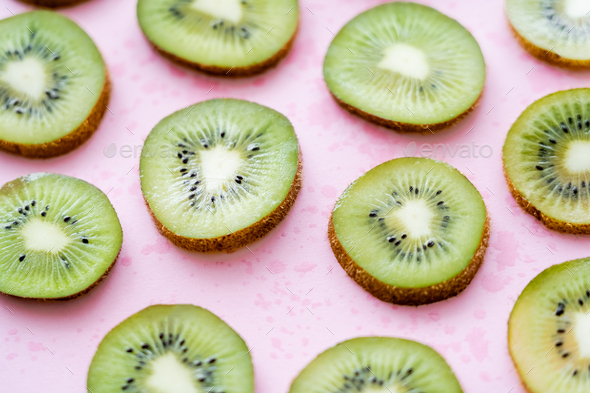 flat lay of organic kiwi fruit on green and pink Stock Photo by  LightFieldStudios