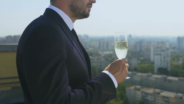 Successful Businessman Drinking Champagne Glass on Office Terrace, Celebration