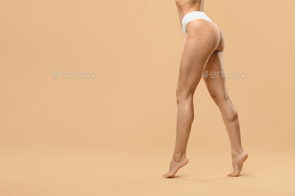 legs and feet of unrecognizable young woman with white thong