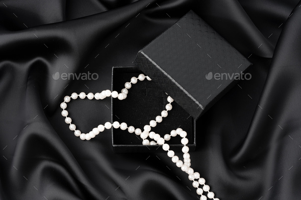 White pearls on the black silk background, Stock image