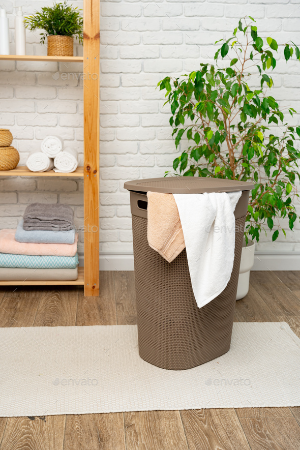 Pile of clothes in plastic laundry basket in the bathroom Stock Photo