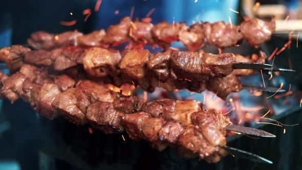 Cook making a barbecue on a grill at food festival alt