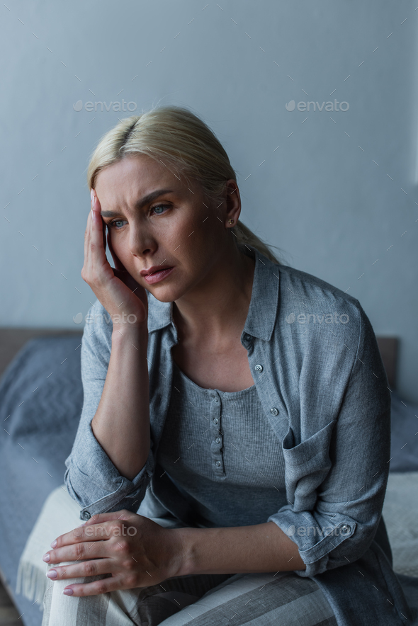 exhausted blonde woman with menopause suffering from headache in