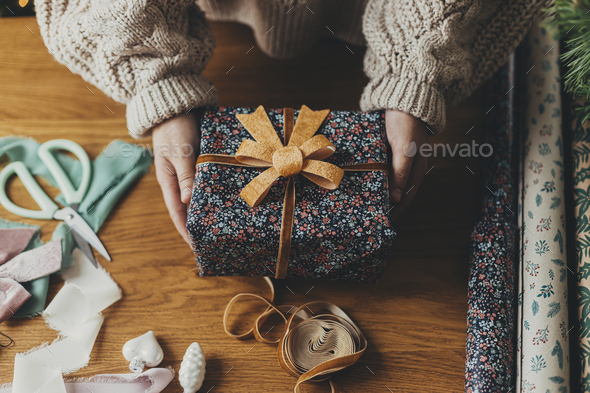 Stylish christmas gift wrapped in gold paper and green ribbon, festive  decorations on green Stock Photo by Sonyachny