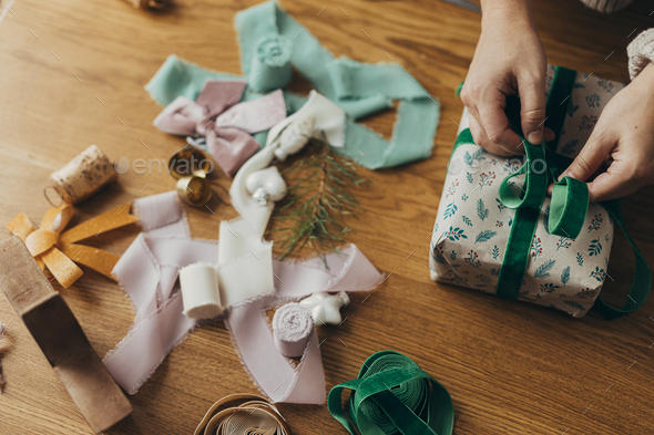 Wrapping christmas gifts. Stylish festive wrapping paper, ribbons