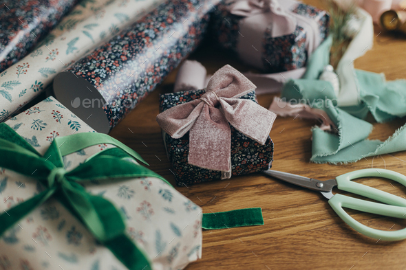 Wrapping christmas gifts. Stylish festive wrapping paper, ribbons