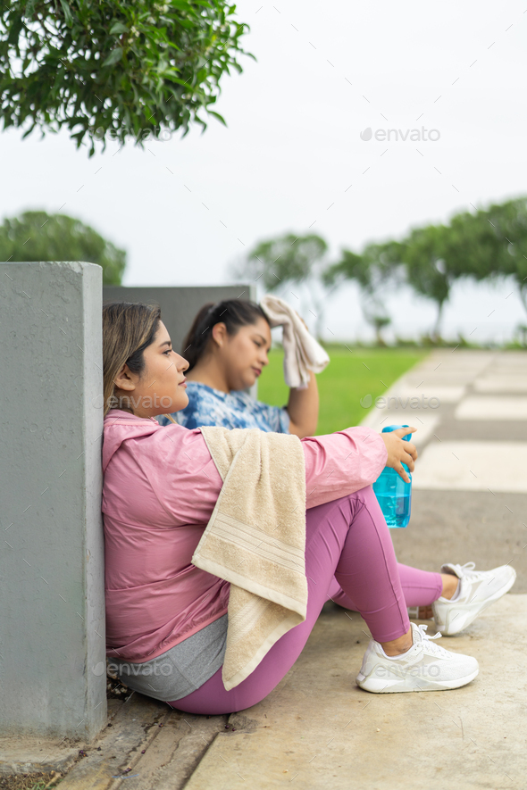 Tired fat runners sitting on a park after exercise