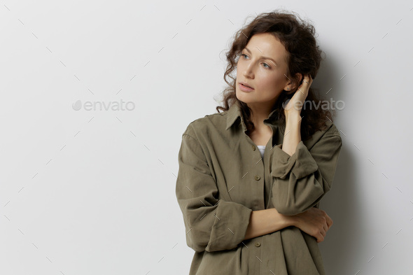 Frustrated pensive curly beautiful woman in casual khaki green shirt thinks about abusive