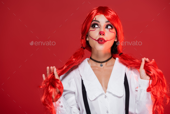 Cute red-haired clown.Girl in bright clown makeup. Close up. Stock Photo